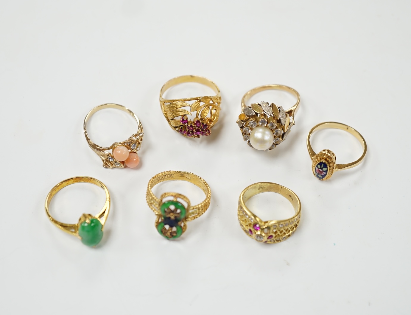 A Middle Eastern 750 yellow metal and two colour enamel up-finger ring, size M, a Chinese 750 yellow metal and gem set cluster ring, gross weight 9.4 grams, a 14k and jade set ring, gross weight 2.8 grams and three assor